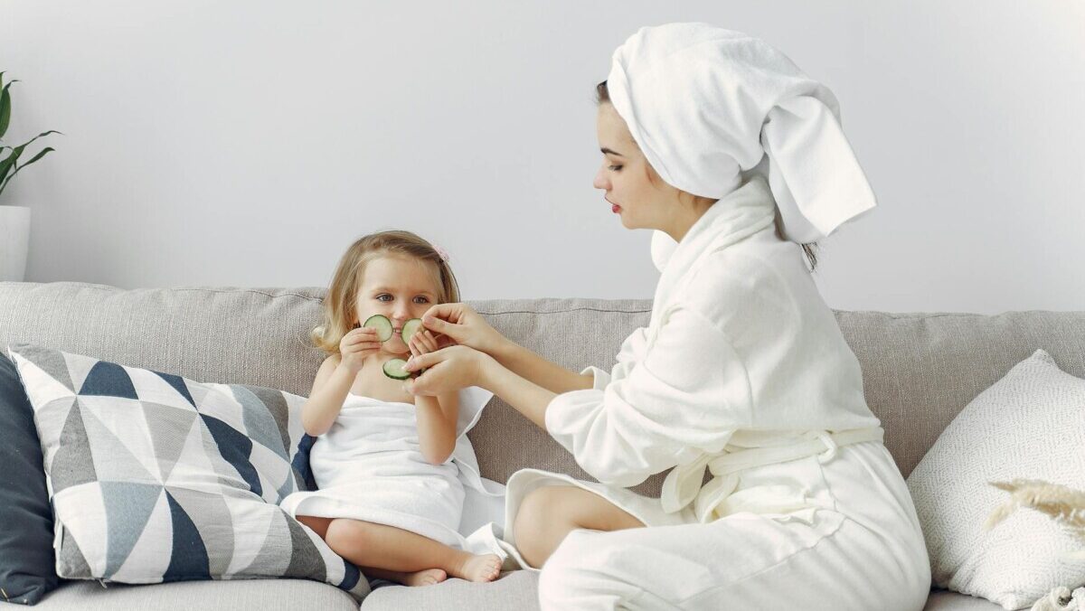 photo of mother and daughter sitting on gray couch